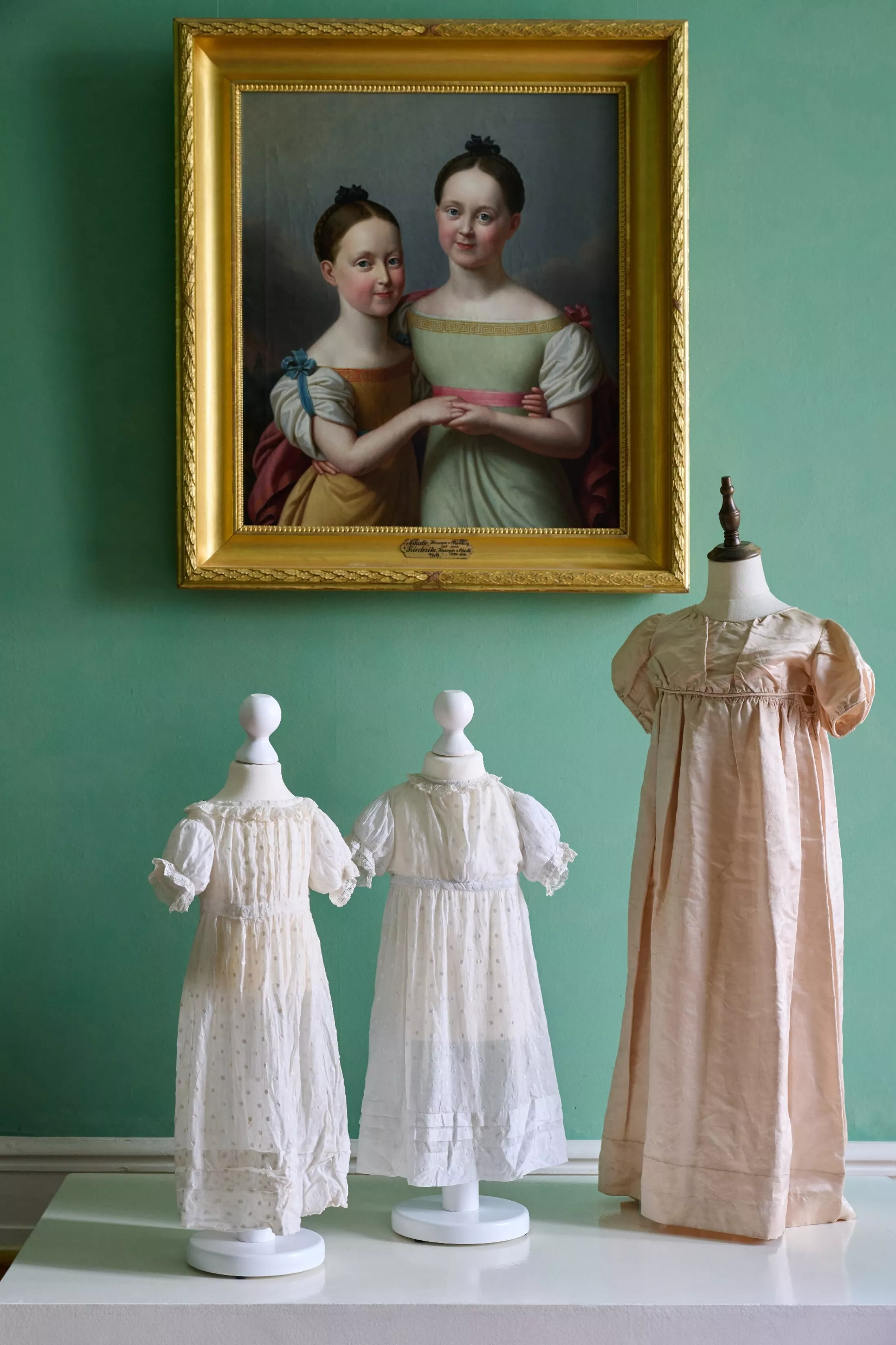 Mädchenkleider, um 1800, weißer, gepunkteter Musselin und Kinderkleid, um 1800, altrosa Seide.